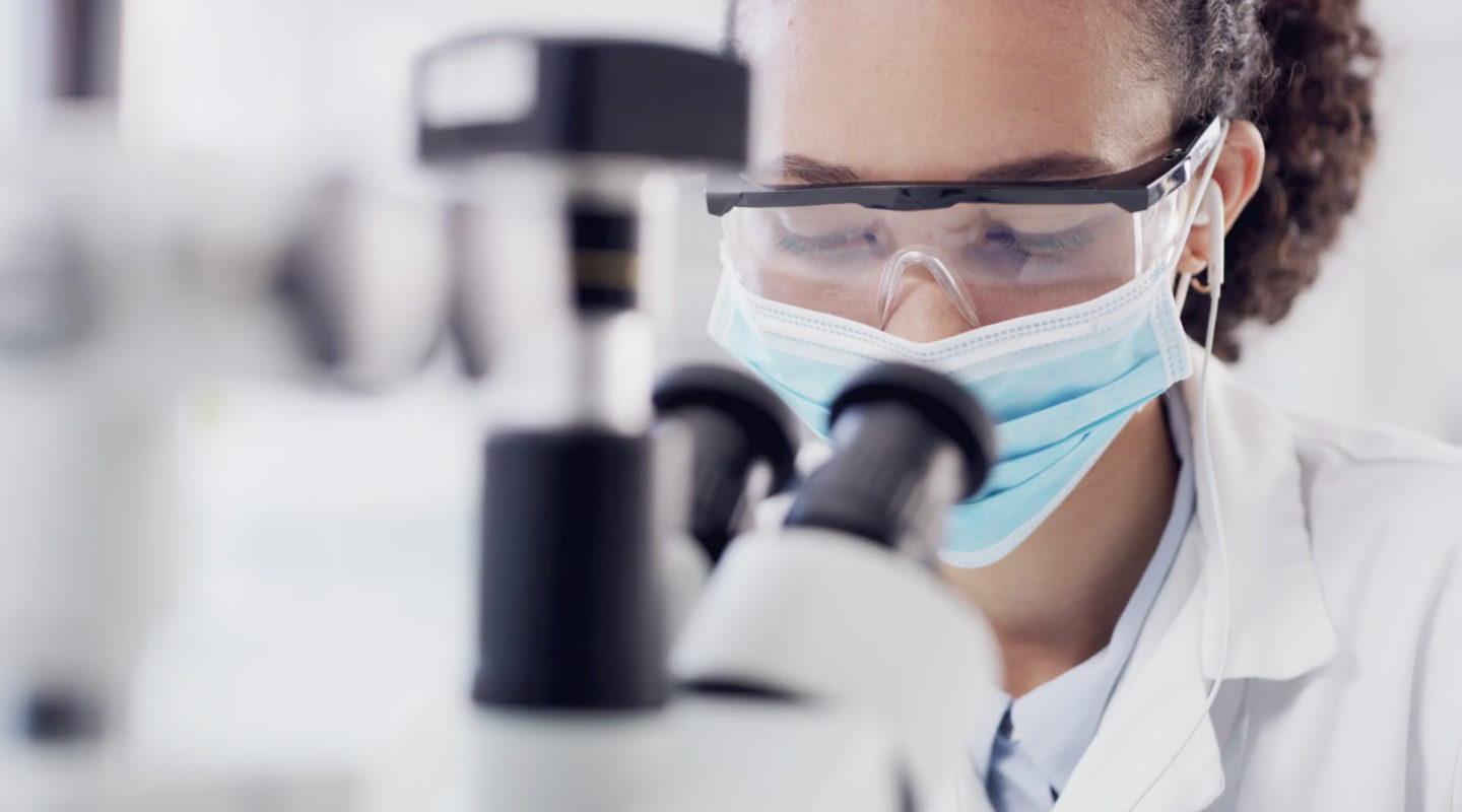 Researcher looking through microscope